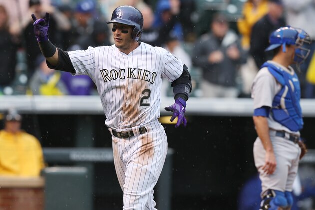 Colorado Rockies' Troy Tulowitzki, front, gestures as he crosses home plate after hitting a solo home run as Los Angeles Dodgers catcher Drew Butera looks on in the fourth inning of a baseball game in Denver on Sunday, June 8, 2014. (AP Photo/David Zalubowski)