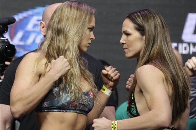 Ronda Rousey, left, and Alexis Davis pose for photographers during a weigh-in for the UFC 175 mixed martial arts event at the Mandalay Bay, Friday, July 4, 2014, in Las Vegas. The two are scheduled to fight in a women's bantamweight title bout on Saturday in Las Vegas. (AP Photo/John Locher)