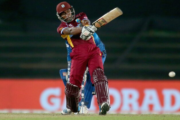 DHAKA, BANGLADESH - APRIL 03:  Dwayne Bravo of the West Indies bats as Kumar Sangakkara of Sri Lanka looks on during the ICC World Twenty20 Bangladesh 2014 1st Semi-Final match between Sri Lanka and the West Indies at Sher-e-Bangla Mirpur Stadium on April 3, 2014 in Dhaka, Bangladesh.  (Photo by Scott Barbour/Getty Images)