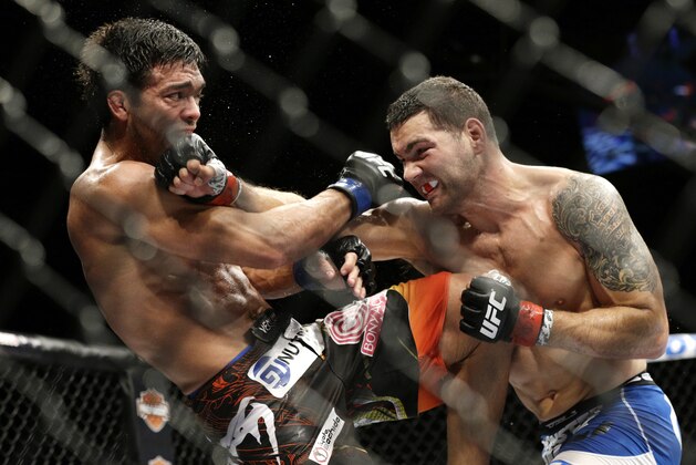 Chris Weidman, right, hits Lyoto Machida during their mixed martial arts middleweight title bout at UFC 175 Saturday, July 5, 2014, in Las Vegas. (AP Photo/John Locher)