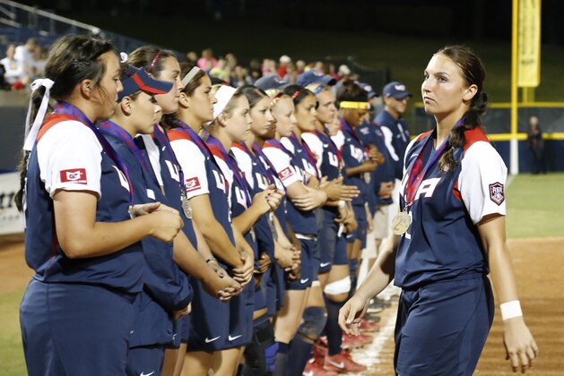 United State's Jessica Moore, right, walks back to her team after accepting her second place medal following the World Cup of Softball tournament championship game against Japan in Oklahoma City, Sunday, July 14, 2013. Japan won 6-3. (AP Photo/Sue Ogrocki)