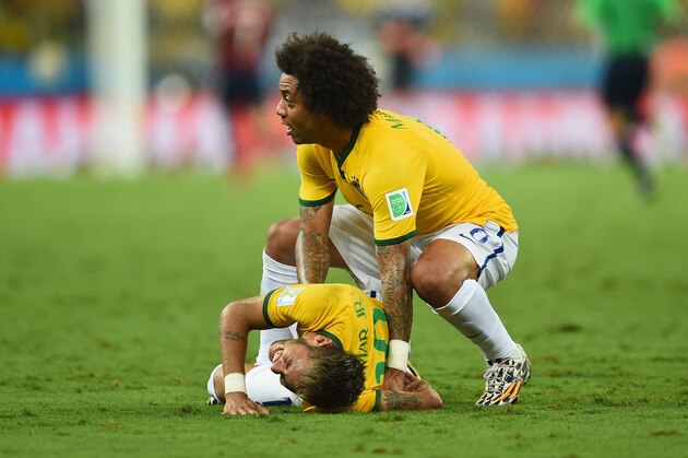 FORTALEZA, BRAZIL - JULY 04:  Neymar of Brazil lies on the field after a challenge as teammate Marcelo reacts during the 2014 FIFA World Cup Brazil Quarter Final match between Brazil and Colombia at Castelao on July 4, 2014 in Fortaleza, Brazil.  (Photo by Jamie McDonald/Getty Images)