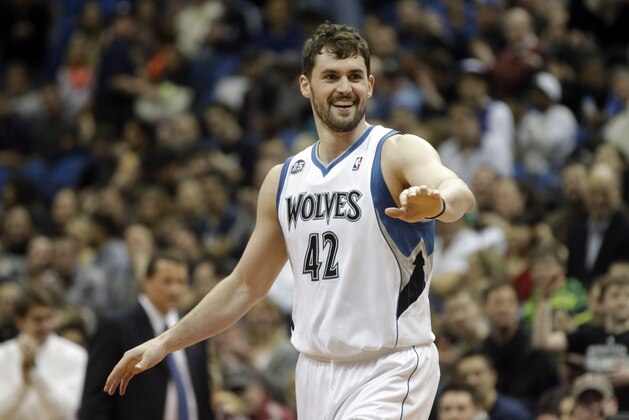Minnesota Timberwolves' Kevin Love , left, congratulates Corey Brewer after Brewer's dunk in the first quarter of an NBA basketball game against the Detroit Pistons, Friday, March 7, 2014, in Minneapolis. (AP Photo/Jim Mone)