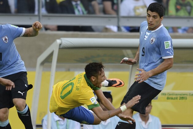 Brazil's Neymar, second right, is airborne after a tackle by Uruguay's Luis Suarez, right, as Uruguay's Egidio Arevalo, left, and Cristian Rodriguez look on during the soccer Confederations Cup semifinal match between Brazil and Uruguay at the Mineirao stadium in Belo Horizonte, Brazil, Wednesday, June 26, 2013. (AP Photo/Eugenio Savio)