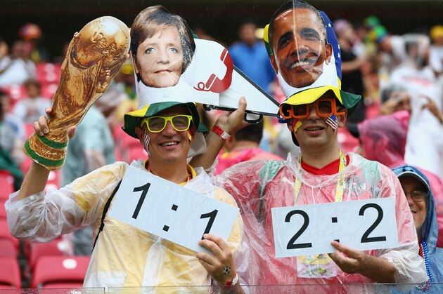 RECIFE, BRAZIL - JUNE 26: Fans hold up a replica of the World Cup trophy while wearing masks of Angela Merkel and Barack Obama during the 2014 FIFA World Cup Brazil group G match between the United States and Germany at Arena Pernambuco on June 26, 2014 in Recife, Brazil. (Photo by Robert Cianflone/Getty Images) RECIFE, BRAZIL - JUNE 26: Fans hold up a replica of the World Cup trophy while wearing masks of Angela Merkel and Barack Obama during the 2014 FIFA World Cup Brazil group G match between the United States and Germany at Arena Pernambuco on June 26, 2014 in Recife, Brazil. (Photo by Robert Cianflone/Getty Images)
