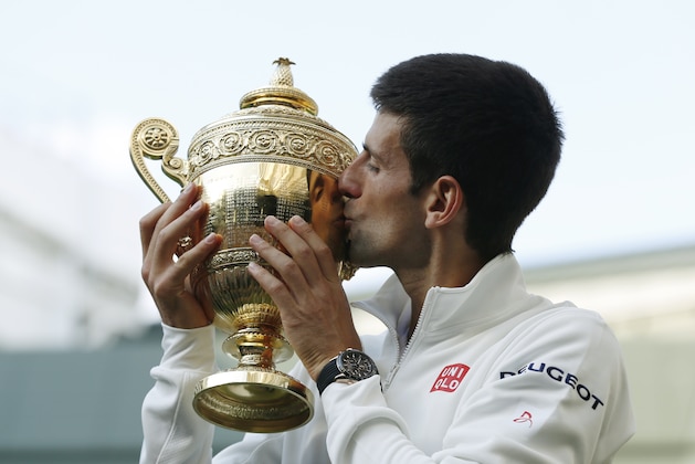 Novak Djokovic of Serbia kisses the trophy after defeating Roger Federer of Switzerland in the men's singles final match at the All England Lawn Tennis Championships in Wimbledon, London, Sunday July 6, 2014. (AP Photo/Sang Tan, Pool)