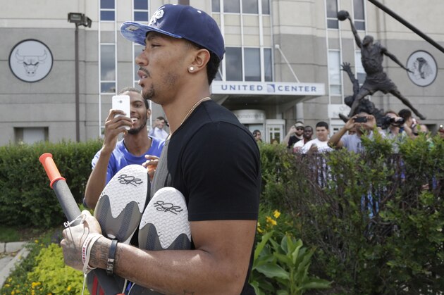 Chicago Bulls star Derrick Rose leaves the United Center after the Bulls met with NBA free agent Carmelo Anthony at the facility Tuesday, July 1, 2014, in Chicago. The Bulls believe they have a strong pitch and a simple selling point: Anthony can transform a playoff team into a championship contender. They believe uniting Anthony with Derrick Rose and Joakim Noah, who arrived earlier at the arena, would put them in position to contend for their first title since Jordan and Scottie Pippen led the way to two three-peats in the 1990s. (AP Photo/M. Spencer Green)