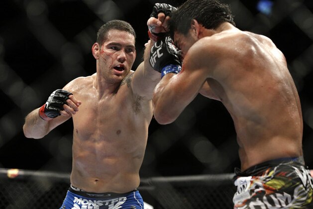 Chris Weidman, left, hits Lyoto Machida during their mixed martial arts middleweight title bout at UFC 175 Saturday, July 5, 2014, in Las Vegas. (AP Photo/John Locher)