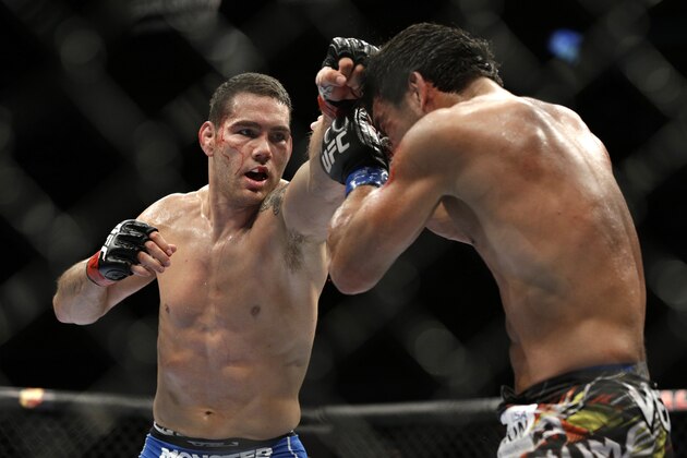 Chris Weidman, left, hits Lyoto Machida during their mixed martial arts middleweight title bout at UFC 175 Saturday, July 5, 2014, in Las Vegas. (AP Photo/John Locher)