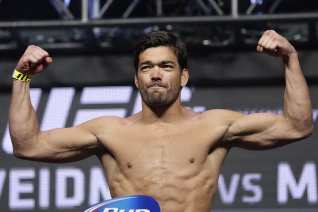 Lyoto Machida poses on the scale during a weigh-in for the UFC 175 mixed martial arts event at the Mandalay Bay, Friday, July 4, 2014, in Las Vegas. Machida is scheduled to fight Chris Weidman in a middleweight title bout on Saturday in Las Vegas. (AP Photo/John Locher)