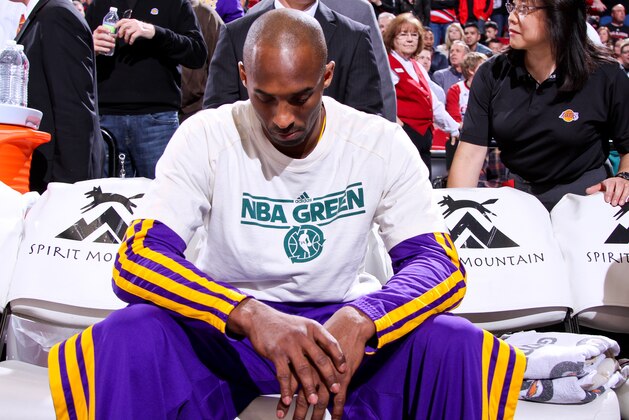 PORTLAND, OR - APRIL 10: Kobe Bryant #24 of the Los Angeles Lakers, wearing an NBA Green Week T-shirt, sits on the bench before playing against the Portland Trail Blazers on April 10, 2013 at the Rose Garden Arena in Portland, Oregon. NOTE TO USER: User expressly acknowledges and agrees that, by downloading and or using this photograph, user is consenting to the terms and conditions of the Getty Images License Agreement. Mandatory Copyright Notice: Copyright 2013 NBAE (Photo by Sam Forencich/NBAE via Getty Images)