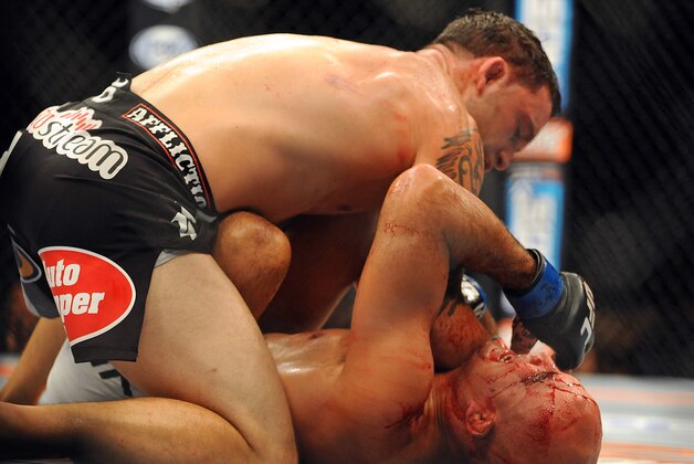 Jul 6, 2014; Las Vegas, NV, USA; Frankie Edgar (red gloves) hits B.J. Penn (blue gloves) during their featherweight bout at Mandalay Bay Events Center. Mandatory Credit: Stephen R. Sylvanie-USA TODAY Sports