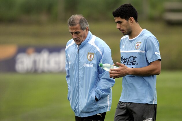 Uruguay coach Oscar Tabarez, left, and striker Luis Suarez walk together on the pitch after a training session on the outskirts of Montevideo, Tuesday, Oct. 9, 2012. Uruguay will face Argentina in a World Cup 2014 qualifying soccer game on Friday. (AP Photo/Matilde Campodonico)