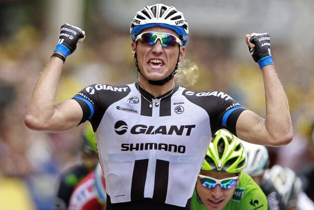 Germany's sprinter Marcel Kittel crosses the finish line ahead of celebrates on the podiums, bottom right, to win the third stage of the Tour de France cycling race over 155 kilometers (96.3 miles) with start in Cambridge and finish in London, England, Monday, July 7, 2014. (AP Photo/Peter Dejong)