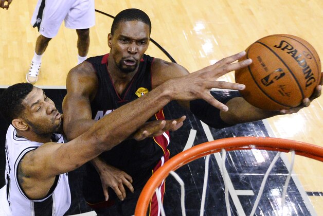 Miami Heat center Chris Bosh shoots as San Antonio Spurs forward Tim Duncan, left, defends during the first half in Game 2 of the NBA basketball finals on Saturday, Nov. 8, 2014, in San Antonio. (AP Photo/Larry W. Smith, pool)