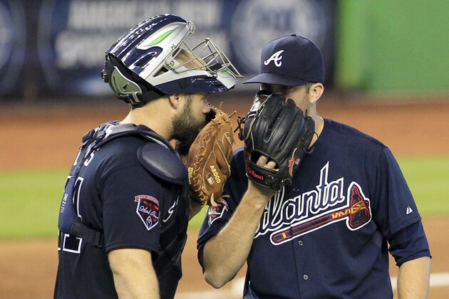 Atlanta Braves catcher Evan Gattis, left, confers with starting pitcher Alex Wood in the seventh inning during their baseball game with the Miami Marlins in Miami, Sunday, June 1, 2014. (AP Photo/Joe Skipper)