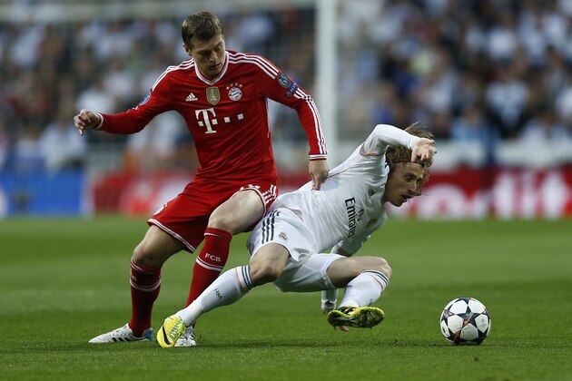 Real's Luka Modric fights for the ball with Bayern's Toni Kroos, left, during a first leg semifinal Champions League soccer match between Real Madrid and Bayern Munich at the Santiago Bernabeu stadium in Madrid, Spain, Wednesday, April 23, 2014. (AP Photo/Andres Kudacki)