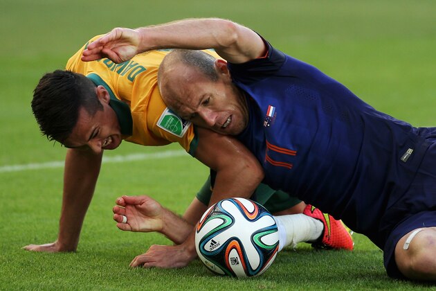 PORTO ALEGRE, BRAZIL - JUNE 18:  Arjen Robben of the Netherlands and Jason Davidson of Australia battle for the ball on the pitch during the 2014 FIFA World Cup Brazil Group B match between Australia and Netherlands at Estadio Beira-Rio on June 18, 2014 in Porto Alegre, Brazil. (Photo by Dean Mouhtaropoulos/Getty Images)