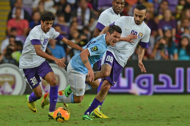 Manchester City player Marcos Lopes, centre, is tackled by UAE's Al-Ain club players during a friendly match in Al Ain, United Arab Emirates, Thursday, May 15, 2014. (AP Photo)