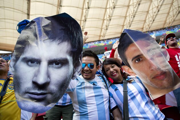 Fans of Argentina's national soccer team hold face cutouts of Lionel Messi, left, and Angel Di Maria, during the World Cup quarterfinal match between Argentina and Belgium at the Estadio Nacional  in Brasilia, Brazil, Saturday, July 5, 2014. (AP Photo/Rodrigo Abd)