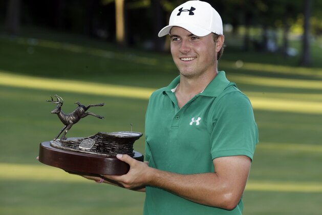 Jordan Spieth holds the trophy after winning the John Deere Classic golf tournament, Sunday, July 14, 2013, at TPC Deere Run in Silvis, Ill.  Spieth defeated Zach Johnson and David Hearn on the fifth hole of a playoff. (AP Photo/Charlie Neibergall)