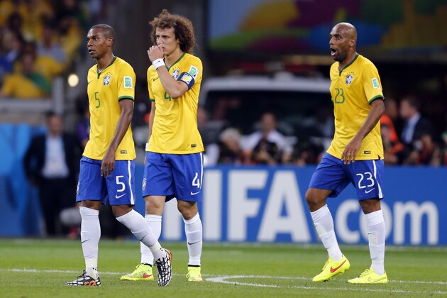 Brazil's Fernandinho, David Luiz and Maicon, from left, walk over the pitch after Germany scored their fifth goal during the World Cup semifinal soccer match between Brazil and Germany at the Mineirao Stadium in Belo Horizonte, Brazil, Tuesday, July 8, 2014. (AP Photo/Frank Augstein)
