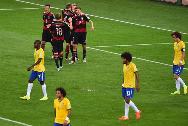 BELO HORIZONTE, BRAZIL - JULY 08: Andre Schuerrle of Germany celebrates scoring his team's sixth goal with teammates Mesut Oezil, Toni Kroos, Benedikt Hoewedes and Thomas Mueller as dejected Brazil players look on during the 2014 FIFA World Cup Brazil Semi Final match between Brazil and Germany at Estadio Mineirao on July 8, 2014 in Belo Horizonte, Brazil.  (Photo by Jamie McDonald/Getty Images)