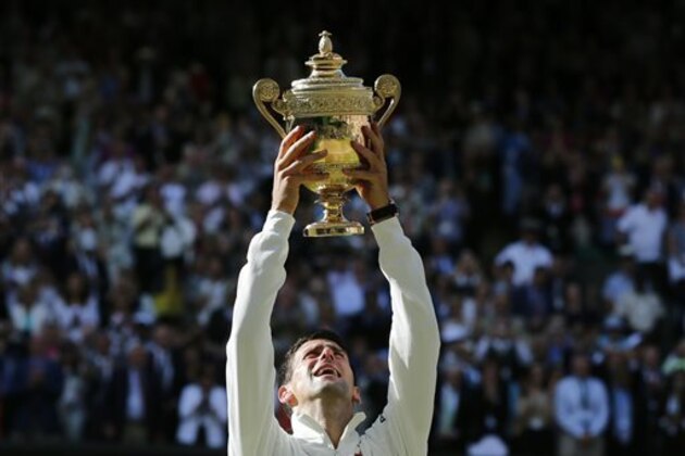 Novak Djokovic of Serbia holds up the trophy after defeating Roger Federer of Switzerland in the men's singles final at the All England Lawn Tennis Championships in Wimbledon, London, Sunday, July 6, 2014. (AP Photo/Ben Curtis)