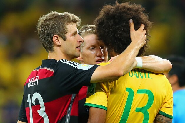 BELO HORIZONTE, BRAZIL - JULY 08: Thomas Mueller (L) and Bastian Schweinsteiger of Germany console Dante of Brazil after Germany's 7-1 win during the 2014 FIFA World Cup Brazil Semi Final match between Brazil and Germany at Estadio Mineirao on July 8, 2014 in Belo Horizonte, Brazil.  (Photo by Martin Rose/Getty Images)