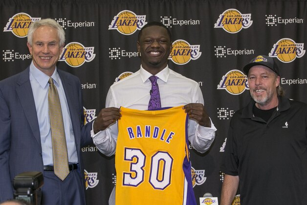 The Los Angeles Lakers owner general manager Mitch Kupchak, left, and Lakers part-owner and executive vice president of basketball operations of the Los Angeles Lakers, Jim Buss, right, introduce forward Julius Randle, middle, Monday, June 30, 2014 in El Segundo, Calif. Former Kentucky forward Julius Randle was selected seventh overall by the Lakers during the 2014 NBA draft. (AP Photo/Damian Dovarganes)