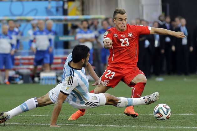 Switzerland's Xherdan Shaqiri is challenged during the World Cup round of 16 soccer match between Argentina and Switzerland at the Itaquerao Stadium in Sao Paulo, Brazil, Tuesday, July 1, 2014. (AP Photo/Sergei Grits)