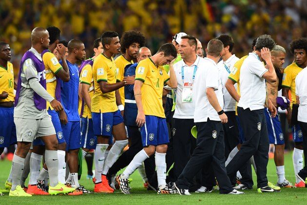 BELO HORIZONTE, BRAZIL - JULY 08:  Oscar of Brazil (center) reacts with teammates after being defeated 7-1 by Germany  during the 2014 FIFA World Cup Brazil Semi Final match between Brazil and Germany at Estadio Mineirao on July 8, 2014 in Belo Horizonte, Brazil.  (Photo by Buda Mendes/Getty Images)