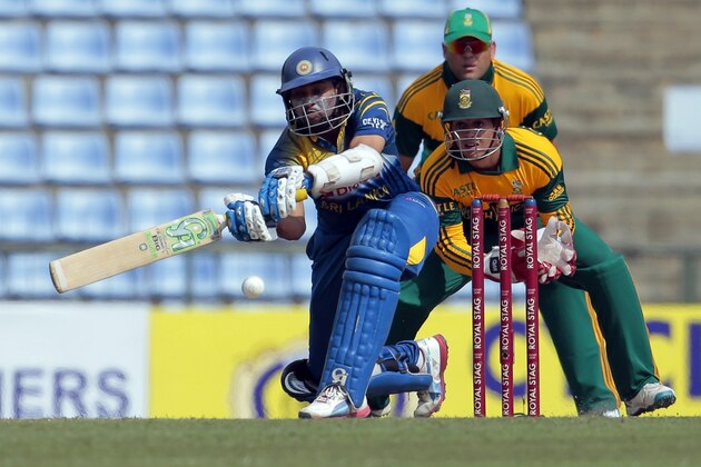 Sri Lankan cricketer Tillakaratne Dilshan bats in front of South African wicketkeeper Quinton de Kock and Jacques Kallis during their second one-day international cricket match in Pallekele, Sri Lanka, Wednesday, July 9, 2014. (AP Photo/Eranga Jayawardena)