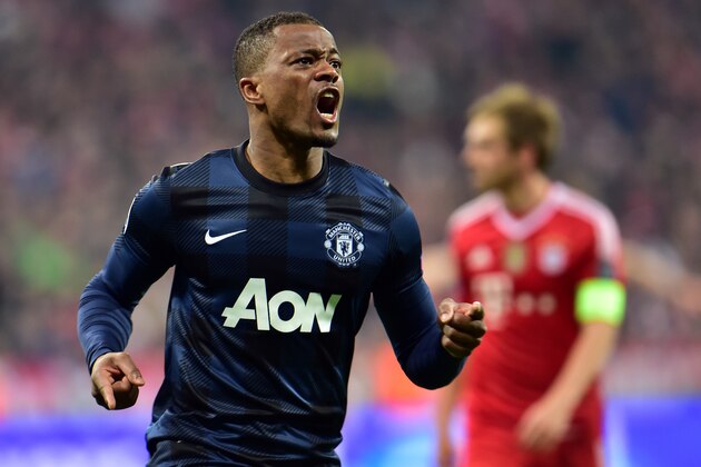 Manchester United's Patrice Evra, left, celebrates his side's opening goal during the Champions League quarterfinal second leg soccer match between Bayern Munich and Manchester United in the Allianz Arena in Munich, Germany, Wednesday, April 9, 2014. At right is Bayern's Philipp Lahm. (AP Photo/Kerstin Joensson)