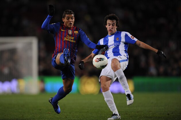 BARCELONA, SPAIN - FEBRUARY 04:  Jonathan dos Santos (L) of FC Barcelona duels for the ball with Pardo of Real Sociedad de Futbol during the La Liga match between FC Barcelona and Real Sociedad de Futbol at Camp Nou on February 4, 2012 in Barcelona, Spain.  (Photo by David Ramos/Getty Images)