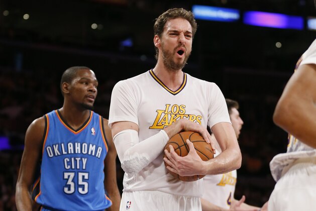 Los Angeles Lakers center Pau Gasol, center, reacts after a foul was called against teammate Ryan Kelley, rear right, as Oklahoma City Thunder small forward Kevin Durant, left, looks on during the first half of an NBA basketball game in Los Angeles, Sunday, March 9, 2014. (AP Photo/Danny Moloshok)