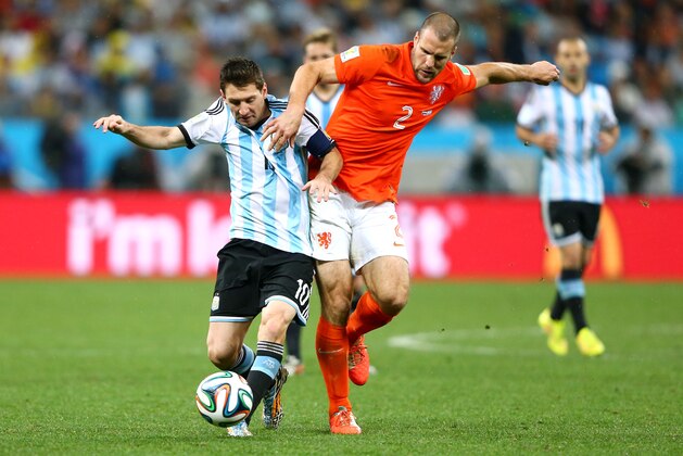 SAO PAULO, BRAZIL - JULY 09: Lionel Messi of Argentina is challenged by Ron Vlaar of the Netherlands during the 2014 FIFA World Cup Brazil Semi Final match between the Netherlands and Argentina at Arena de Sao Paulo on July 9, 2014 in Sao Paulo, Brazil.  (Photo by Jamie Squire/Getty Images)