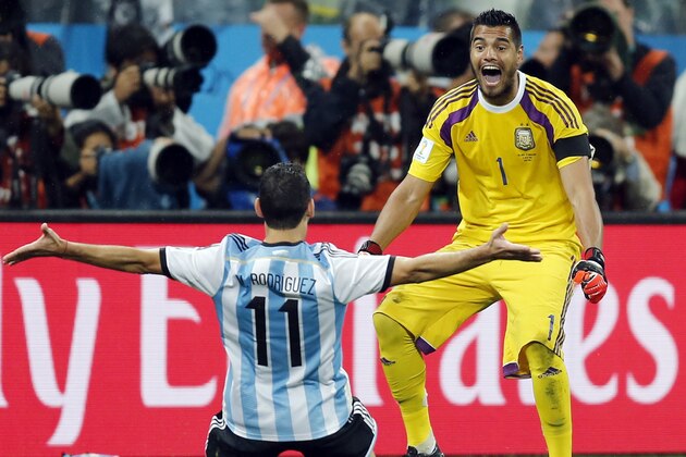 Argentina's Maxi Rodriguez, left, celebrates with goalkeeper Sergio Romero after scoring the decisive goal during the World Cup semifinal soccer match between the Netherlands and Argentina at the Itaquerao Stadium in Sao Paulo, Brazil, Wednesday, July 9, 2014. Argentina beat the Netherlands 4-2 in a penalty shootout to reach the World Cup final. (AP Photo/Frank Augstein)