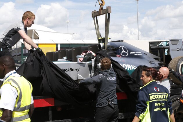 Mechanics cover the car of Germany's Nico Rosberg of Mercedes following  the British Formula One Grand Prix at Silverstone circuit, Silverstone, England, Sunday, July 6, 2014. Rosberg failed to complete the race due to mechanical failure. Britain's Lewis Hamilton of Mercedes won the race, Finland's Valtteri Bottas of Williams finished second and Australia's Daniel Ricciardo of Red Bull finished third.(AP Photo/Lefteris Pitarakis)