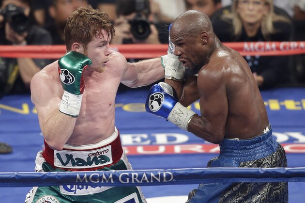Canelo Alvarez, left, throws a punch against Floyd Mayweather Jr. during a 152-pound title fight, Saturday, Sept. 14, 2013, in Las Vegas. (AP Photo/Isaac Brekken)