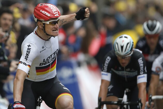 Germany's Andre Greipel looks back as he celebrates crossing the finish line ahead of fourth place Australia's Mark Renshaw, right,  to win the sixth stage of the Tour de France cycling race over 194 kilometers (120.5 miles) with start in Arras and finish in Reims, France, Thursday, July 10, 2014. (AP Photo/Peter Dejong)