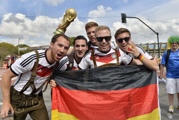 German fans show a flag and a copy of the trophy outside the stadium prior the World Cup semifinal soccer match between Brazil and Germany at the Mineirao Stadium in Belo Horizonte, Brazil, Tuesday, July 8, 2014. (AP Photo/Martin Meissner)