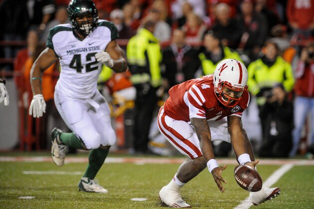 LINCOLN, NE - NOVEMBER 16: Quarterback Tommy Armstrong Jr. #4 of the Nebraska Cornhuskers picks up his fumble in front of defensive end Denzel Drone #42 of the Michigan State Spartans during their game at Memorial Stadium on November 16, 2013 in Lincoln, Nebraska. (Photo by Eric Francis/Getty Images)