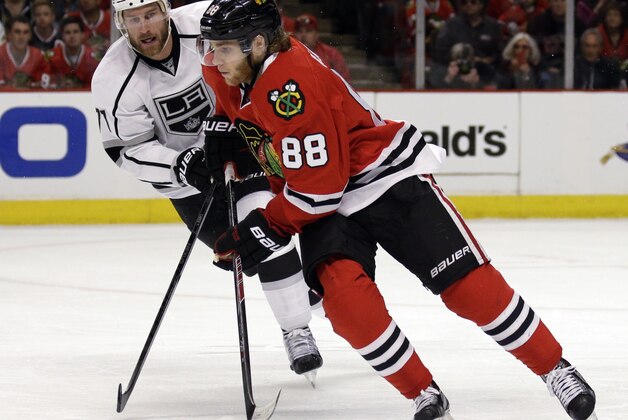 Chicago Blackhawks' Patrick Kane (88), right, controls the puck against Los Angeles Kings' Jeff Carter (77) during the first period in Game 1 of the Western Conference finals in the NHL hockey Stanley Cup playoffs in Chicago on Sunday, May 18, 2014. (AP Photo/Nam Y. Huh)