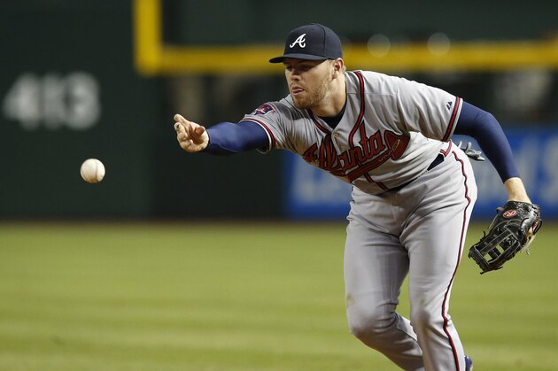 Atlanta Braves' Freddie Freeman tosses the ball to first base after fielding a ground ball hit by Arizona Diamondbacks' Didi Gregorius during the seventh inning of a baseball game on Saturday, June 7, 2014, in Phoenix.  The Diamondbacks defeated the Braves 4-3. (AP Photo/Ross D. Franklin)