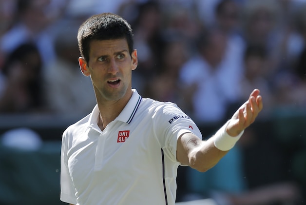 Novak Djokovic of Serbia gestures towards his supporters in the players box as he plays against Roger Federer of Switzerland during their men's singles final match at the All England Lawn Tennis Championships in Wimbledon, London, Sunday, July 6, 2014. (AP Photo/Pavel Golovkin)