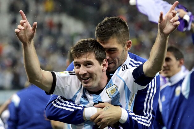 Argentina's Lionel Messi is hugged by a teammate after Argentina defeated the Netherlands 4-2 in a penalty shootout after a 0-0 tie after extra time to advance to the finals during the World Cup semifinal soccer match between the Netherlands and Argentina at the Itaquerao Stadium in Sao Paulo Brazil, Wednesday, July 9, 2014. (AP Photo/Victor R. Caivano)