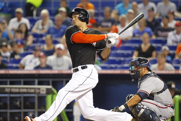 Miami Marlins' Giancarlo Stanton grounds out in the first inning as Atlanta Braves catcher Gerald Laird looks on during a baseball game in Miami, Saturday, May 31, 2014. (AP Photo/Joe Skipper)