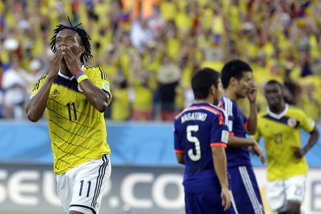Colombia's Juan Cuadrado celebrates after scoring the opening goal from the penalty spot during the group C World Cup soccer match between Japan and Colombia at the Arena Pantanal in Cuiaba, Brazil, Tuesday, June 24, 2014.  (AP Photo/Kirsty Wigglesworth)