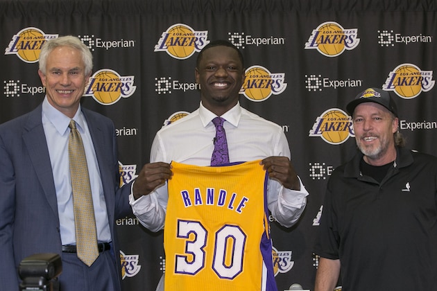 The Los Angeles Lakers owner general manager Mitch Kupchak, left, and Lakers part-owner and executive vice president of basketball operations of the Los Angeles Lakers, Jim Buss, right, introduce forward Julius Randle, middle, Monday, June 30, 2014 in El Segundo, Calif. Former Kentucky forward Julius Randle was selected seventh overall by the Lakers during the 2014 NBA draft. (AP Photo/Damian Dovarganes)